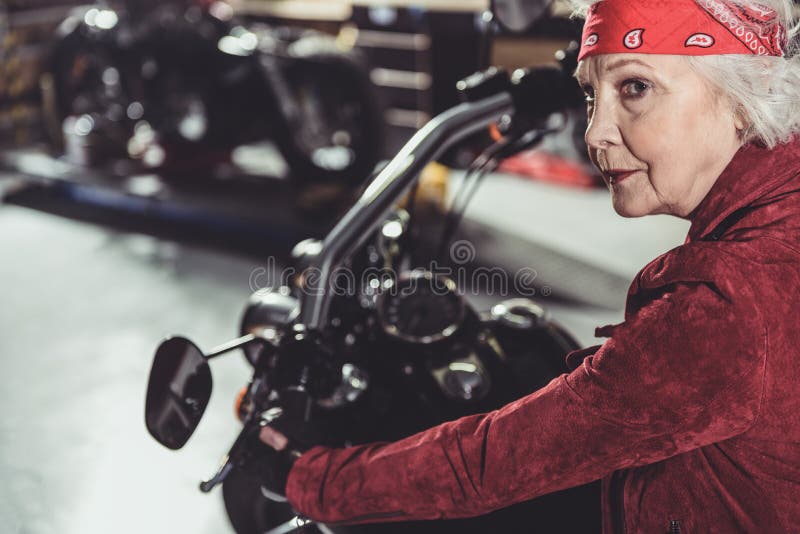 Kühler Rentner, der Fahrrad im Mechanikershop fährt lizenzfreie stockfotografie Kühler Rentner, der Fahrrad im Mechanikershop fährt lizenzfreie stockfotografie
