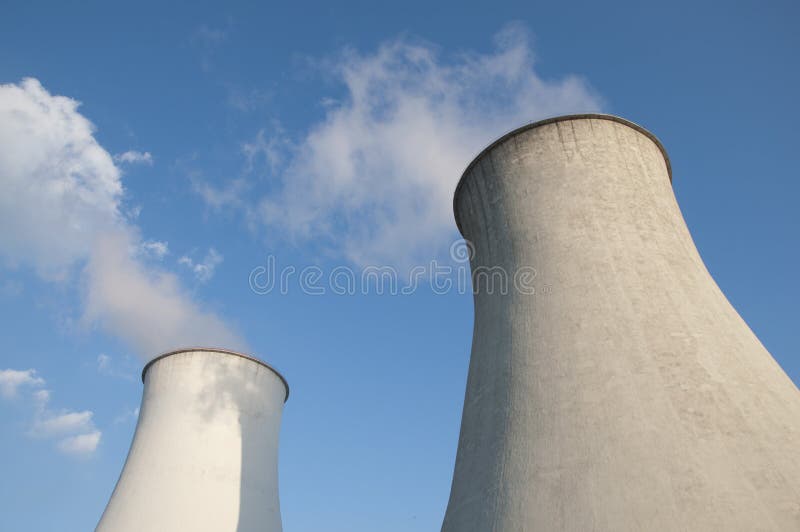 Cooling tower in power plant. Blue sky in background. Cooling tower in power plant. Blue sky in background.
