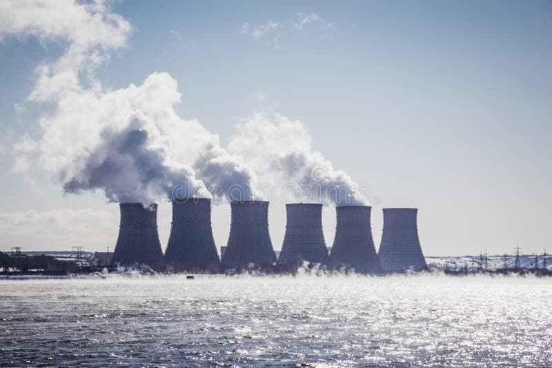 Kühltürme eines Atomkraftwerks oder des NPP mit dickem Rauche auf blauem Himmel lizenzfreies stockfoto