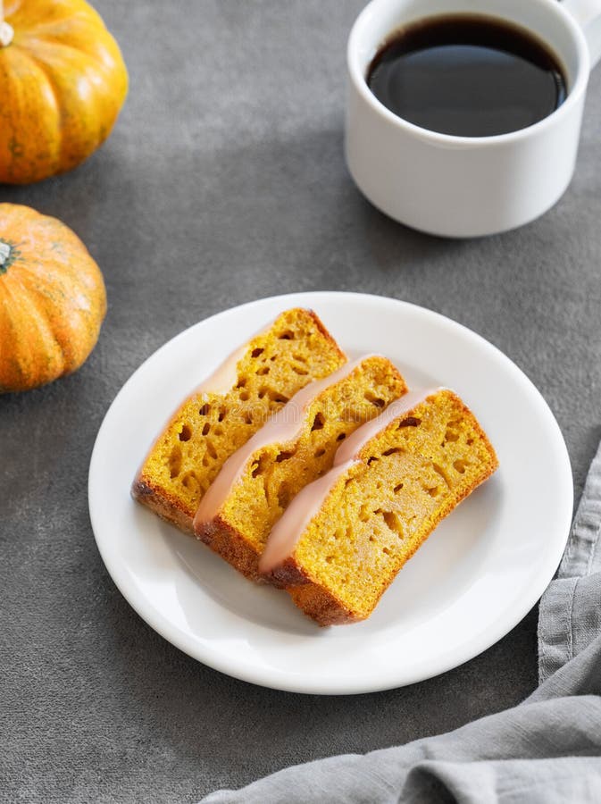 Kürbiskuchen oder Kuchen mit Eis auf einem Teller auf dunklem Hintergrund mit dekorativen Kürbissen und einer Tasse Kaffee stockbilder