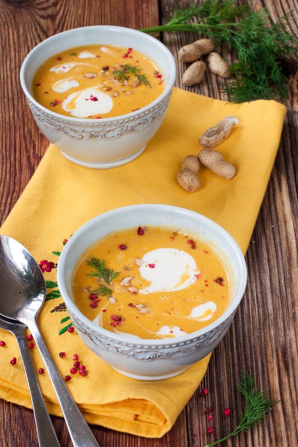 Kürbissuppe mit Erdnüssen auf einem Holztisch lizenzfreie stockfotos