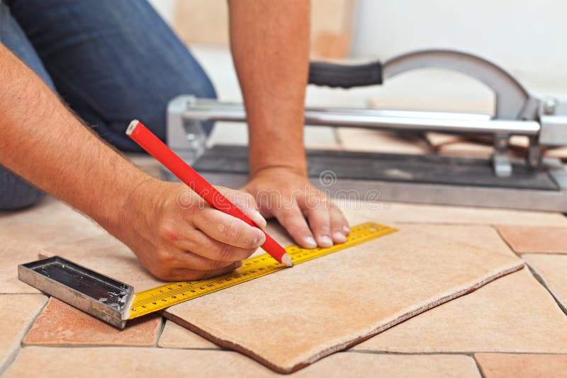 Kłaść ceramiczne podłogowe płytki - mężczyzna wręcza zbliżenie zdjęcie stock Kłaść ceramiczne podłogowe płytki - mężczyzna wręcza zbliżenie zdjęcie stock