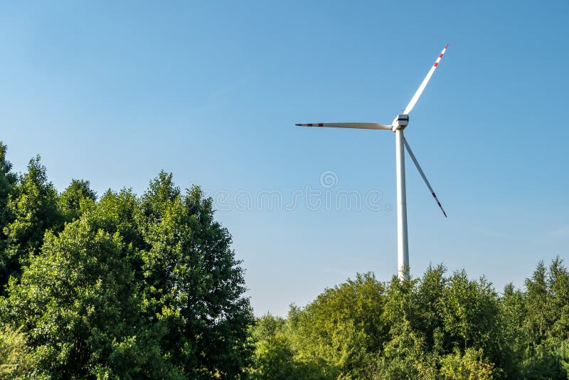 Lâminas rotativas de uma hélice de moinho de vento no fundo do céu azul  geração de energia eólica energia verde pura