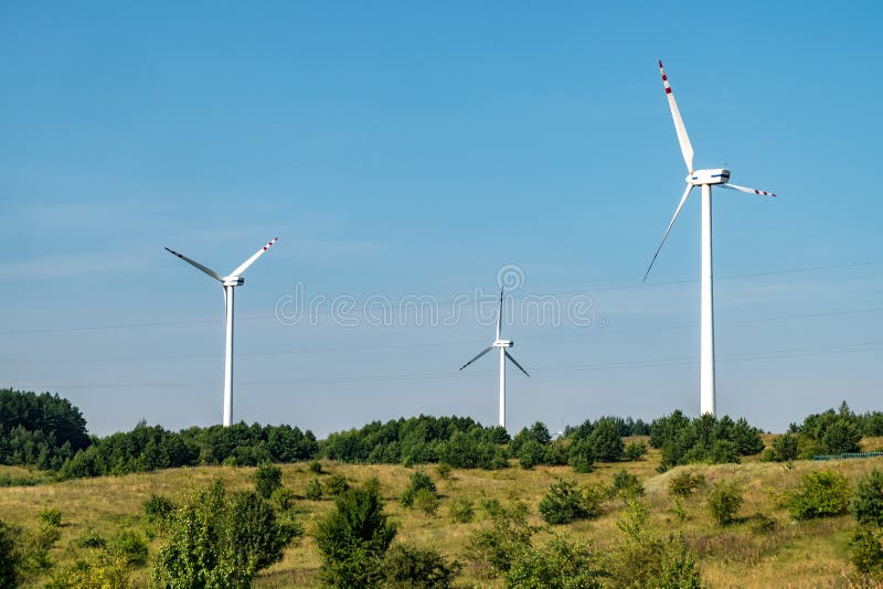 Lâminas rotativas de uma hélice de moinho de vento no fundo do céu azul  geração de energia eólica energia verde pura