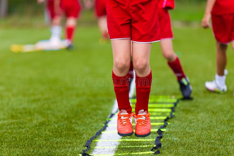 Un Jeune Footballeur Pose Les Exercices D'échelle Pour L