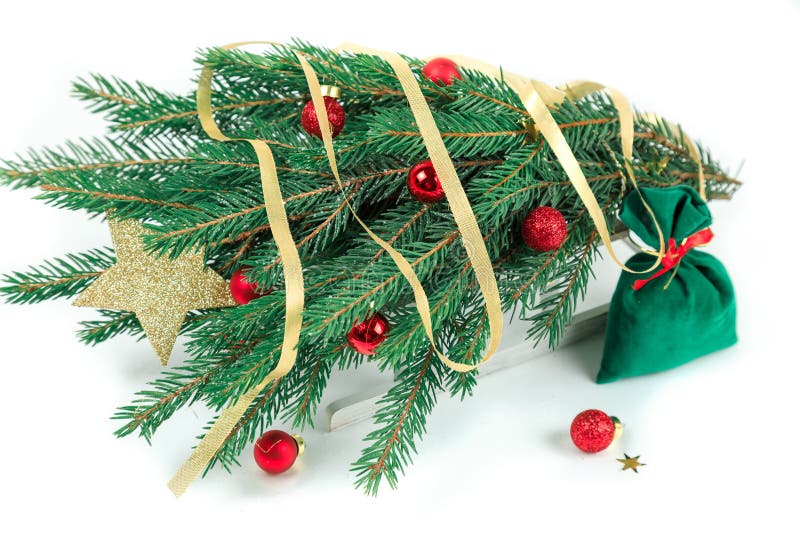 L'abete di Natale con le palle rosse si trova sulla slitta bianca di legno Fondo bianco isolato fotografia stock libera da diritti L'abete di Natale con le palle rosse si trova sulla slitta bianca di legno Fondo bianco isolato fotografia stock libera da diritti