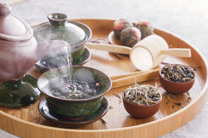 L'acqua bollente da un bollitore ceramico è versata in una tazza della porcellana ad una cerimonia di tè fotografia stock libera da diritti L'acqua bollente da un bollitore ceramico è versata in una tazza della porcellana ad una cerimonia di tè fotografia stock libera da diritti