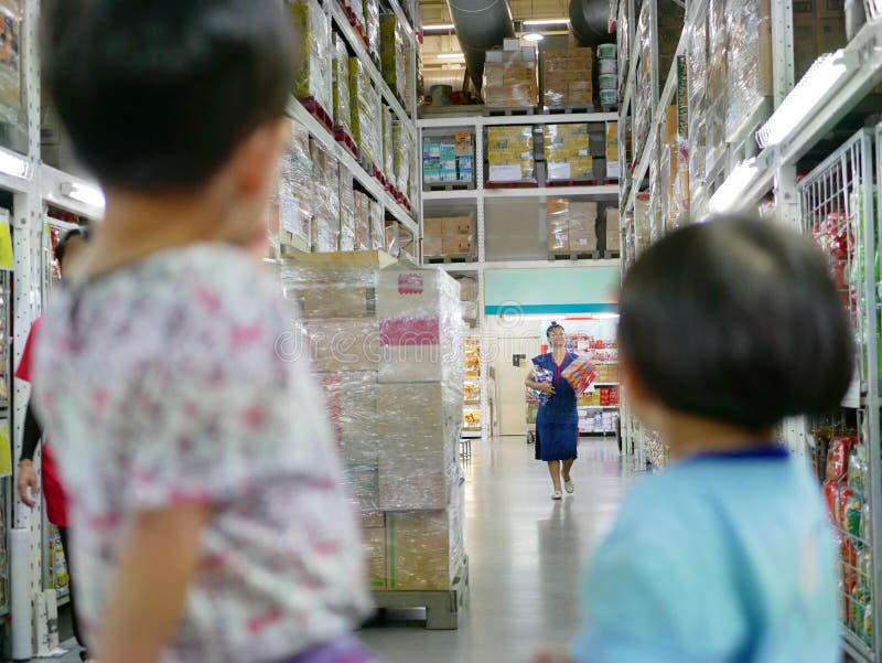 L'acquisto asiatico della madre per gli spuntini nei contanti e porta per i suoi bambini immagini stock libere da diritti L'acquisto asiatico della madre per gli spuntini nei contanti e porta per i suoi bambini immagini stock libere da diritti