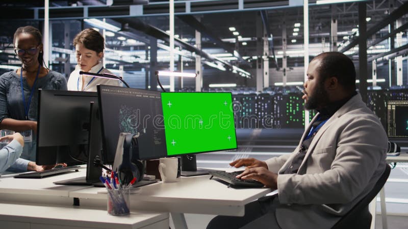 L'administrateur du centre de données inspecte le matériel à l'aide d'un PC mockup à écran vert banque de vidéos