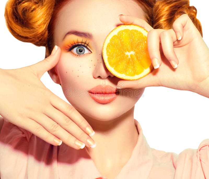 L'adolescente allegro di bellezza prende le arance succose Ragazza di modello teenager con le lentiggini, l'acconciatura rossa di