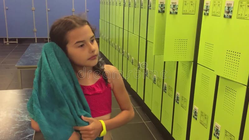 L'adolescente De Fille Dans Le Vestiaire S'essuie Avec La Vidéo Animée Lente Une Serviette Cabines Pour Les Vêtements Changeants Clips Vidéos - Vidéo du vidéo, sport: 99682101 