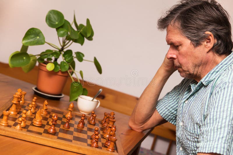 L'adulte supérieur joue des échecs photos stock L'adulte supérieur joue des échecs photos stock