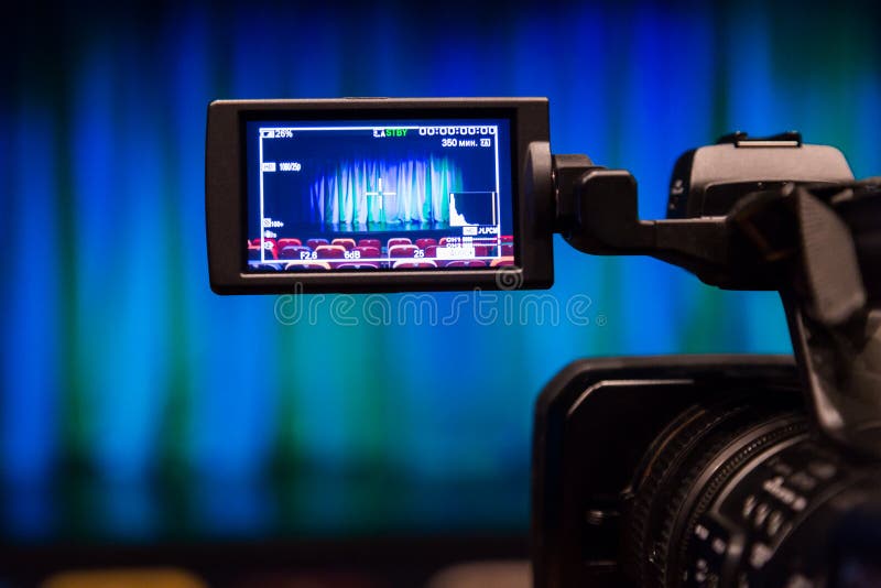 The LCD display on the camcorder. Videography in the theater. Blue-green curtain on the stage. The LCD display on the camcorder. Videography in the theater. Blue-green curtain on the stage.