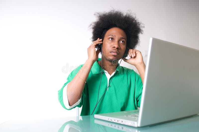 l'Afro-américain écoutent la musique avec l'ordinateur portatif images stock l'Afro-américain écoutent la musique avec l'ordinateur portatif images stock