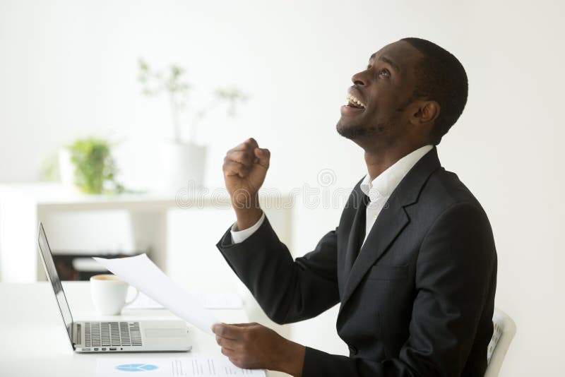 L'afroamericano emozionante soddisfatto con la buona lettura di risultati ha lasciato immagini stock libere da diritti L'afroamericano emozionante soddisfatto con la buona lettura di risultati ha lasciato immagini stock libere da diritti