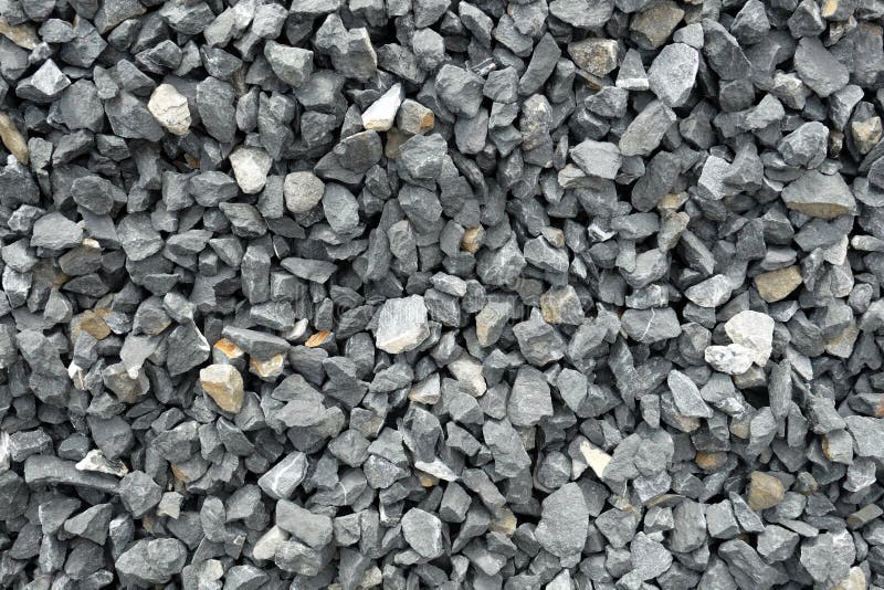 A closeup of a pile of loose rough stones taken at a stone pit. The gravel / grit has been crushed to similar sizes but irregular shapes to be used as construction aggregate and for stone baskets. The rocks are glauconite sandstone which is mostly gray with a slight blue or yellow color tone. The coarse stones and the uneven surface create an abstract pattern which is well usable for backgrounds and textures, resembling solid even being loose. A closeup of a pile of loose rough stones taken at a stone pit. The gravel / grit has been crushed to similar sizes but irregular shapes to be used as construction aggregate and for stone baskets. The rocks are glauconite sandstone which is mostly gray with a slight blue or yellow color tone. The coarse stones and the uneven surface create an abstract pattern which is well usable for backgrounds and textures, resembling solid even being loose.