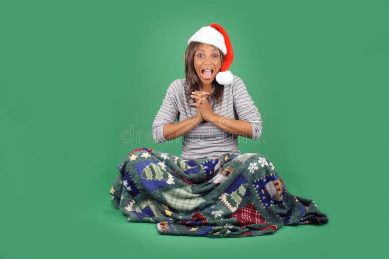 A lovely mature black woman wearing a Santa's helper hat, sits wrapped in a cozy holiday / winter themed blanket. Her facial expression and body language indicates great excitement. There's plenty of blank space for inserting text, logos, graphics, etc. A lovely mature black woman wearing a Santa's helper hat, sits wrapped in a cozy holiday / winter themed blanket. Her facial expression and body language indicates great excitement. There's plenty of blank space for inserting text, logos, graphics, etc.