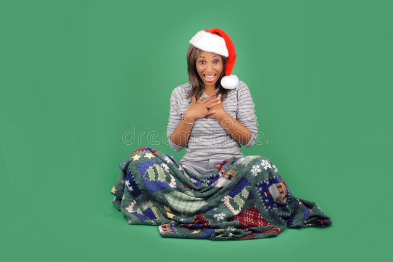 A lovely mature black woman wearing a Santa's helper hat, sits wrapped in a cozy holiday / winter themed blanket. Her facial expression and body language indicates great excitement. There's plenty of blank space for inserting text, logos, graphics, etc. A lovely mature black woman wearing a Santa's helper hat, sits wrapped in a cozy holiday / winter themed blanket. Her facial expression and body language indicates great excitement. There's plenty of blank space for inserting text, logos, graphics, etc.