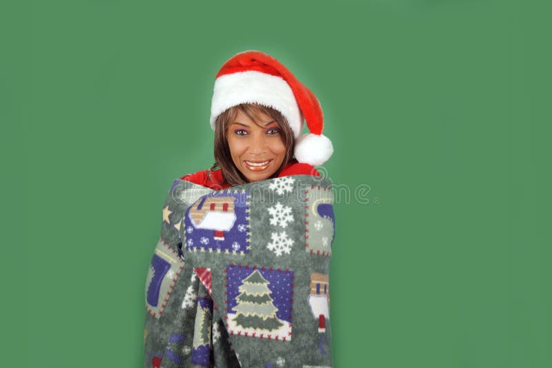 A lovely mature black woman wearing a Santa's helper hat sits with a pleasant smile on a plain green background, holding a unique hand-crafted holiday ornament. There's plenty of blank space for inserting text, logos, graphics, etc. A lovely mature black woman wearing a Santa's helper hat sits with a pleasant smile on a plain green background, holding a unique hand-crafted holiday ornament. There's plenty of blank space for inserting text, logos, graphics, etc.