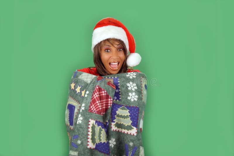 A lovely mature black woman wearing a Santa's helper hat and wrapped in a cozy holiday / winter themed blanket. There's plenty of blank space for inserting text, logos, graphics, etc. A lovely mature black woman wearing a Santa's helper hat and wrapped in a cozy holiday / winter themed blanket. There's plenty of blank space for inserting text, logos, graphics, etc.