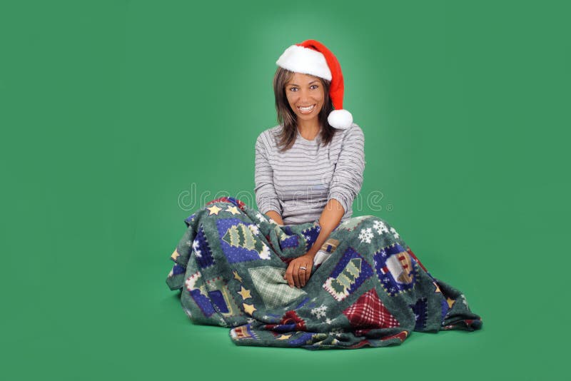 A lovely mature black woman with a bright, warm smile and wearing a Santa's helper hat, sits wrapped in a cozy holiday / winter themed blanket. There's plenty of blank space for inserting text, logos, graphics, etc. A lovely mature black woman with a bright, warm smile and wearing a Santa's helper hat, sits wrapped in a cozy holiday / winter themed blanket. There's plenty of blank space for inserting text, logos, graphics, etc.