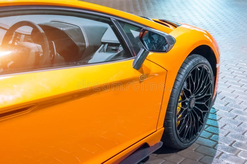 L'ala anteriore e la ruota dell'automobile sono un supercar, alla notte in un parcheggio nella città fotografie stock libere da diritti L'ala anteriore e la ruota dell'automobile sono un supercar, alla notte in un parcheggio nella città fotografie stock libere da diritti