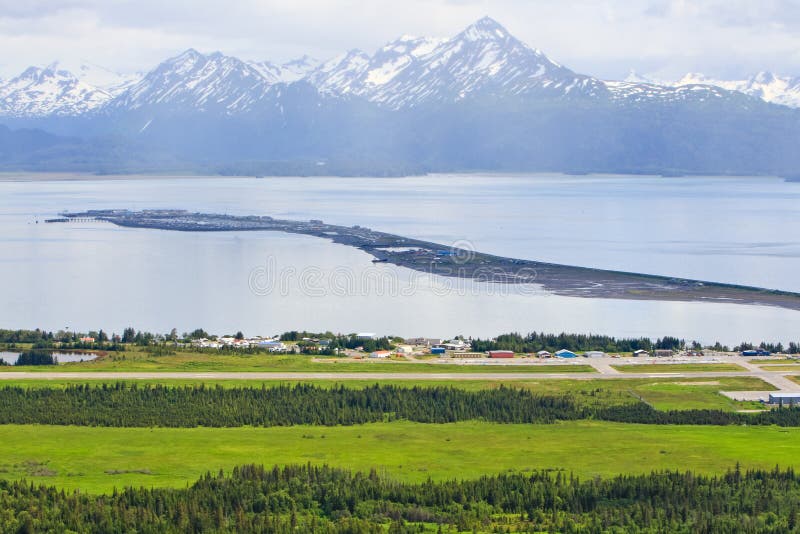 A beautiful view of the Homer Alaska airport, the Kenai Mountains, Kachemak Bay and the world famous Homer Spit from the overlook on East End Road in Homer, Alaska. A common summer cruise ship port of call, located on the very end of the Kenai Peninsula and part of the Pacific Ocean Ring of Fire, Homer is famous for commercial and recreational fishing, particularly halibut, outdoor recreation opportunities, and its eclectic artist vibe is popular with both Alaskans and tourists alike. A beautiful view of the Homer Alaska airport, the Kenai Mountains, Kachemak Bay and the world famous Homer Spit from the overlook on East End Road in Homer, Alaska. A common summer cruise ship port of call, located on the very end of the Kenai Peninsula and part of the Pacific Ocean Ring of Fire, Homer is famous for commercial and recreational fishing, particularly halibut, outdoor recreation opportunities, and its eclectic artist vibe is popular with both Alaskans and tourists alike.