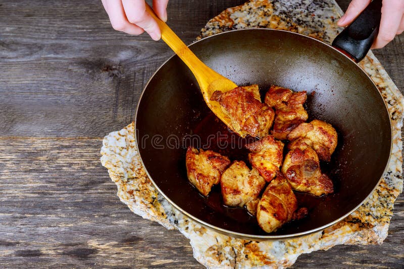 L'alimento che cucina in wok nel tandyr una padella ha fritto la carne immagini stock libere da diritti L'alimento che cucina in wok nel tandyr una padella ha fritto la carne immagini stock libere da diritti