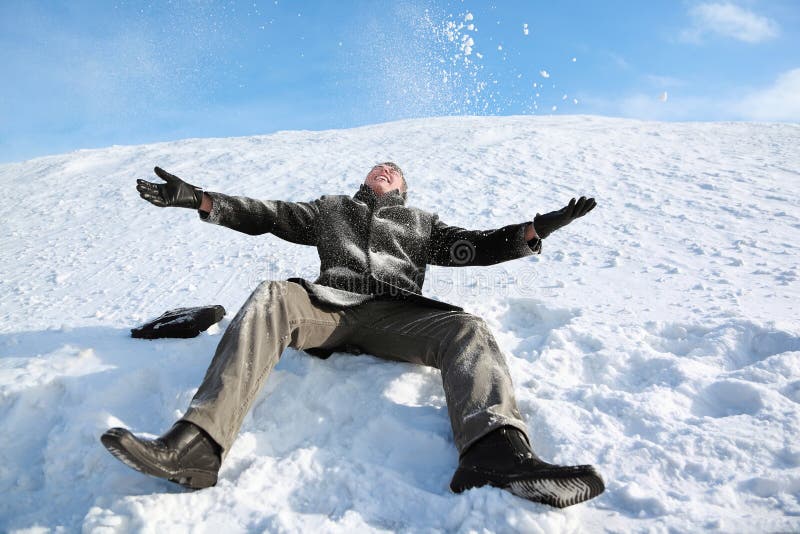L'allievo si siede su neve ed allegro lo getta immagini stock L'allievo si siede su neve ed allegro lo getta immagini stock
