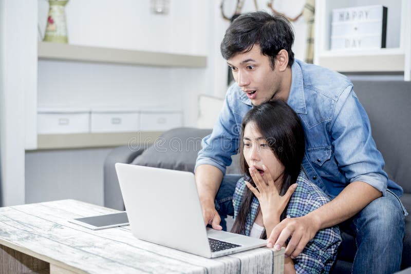 L'amante ? sorprendente quando facendo uso del computer portatile Concetto 'nucleo familiare', concetto degli amanti, concetto di fotografie stock L'amante ? sorprendente quando facendo uso del computer portatile Concetto 'nucleo familiare', concetto degli amanti, concetto di fotografie stock
