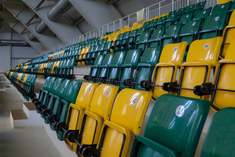 L'amphith??tre dans le complexe de sports avec les si?ges en plastique verts et jaunes Les endroits pour des spectateurs de manif image libre de droits L'amphith??tre dans le complexe de sports avec les si?ges en plastique verts et jaunes Les endroits pour des spectateurs de manif image libre de droits