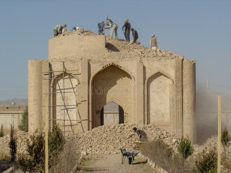 L'ancien bâtiment historique en briques afghanes est démoli par le travail manuel dans les jardins ombragés de gawar en afghanista photographie stock