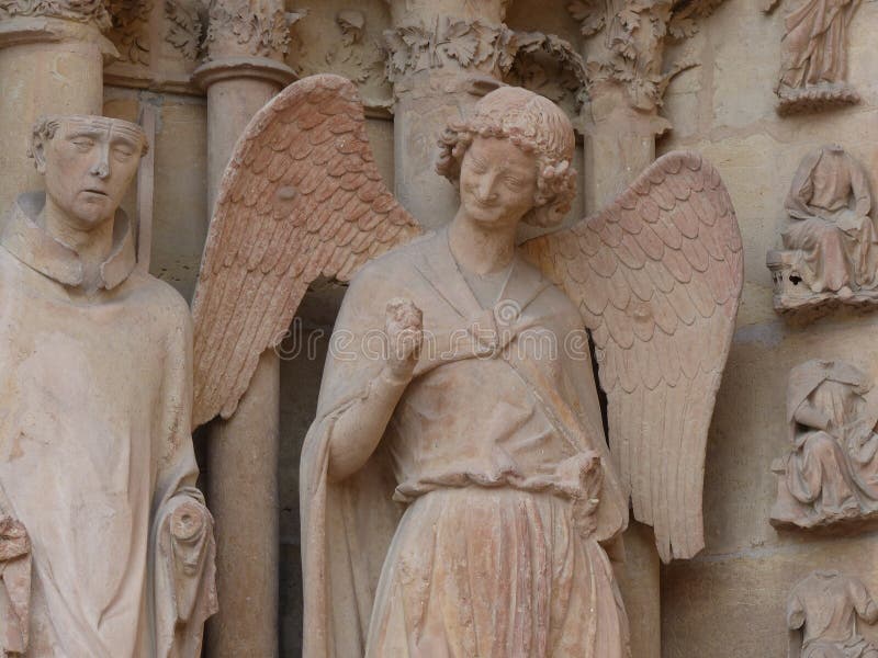 L'ange de sourire avec le sourire de séduction donnant un poing pompent sur l'entrée à la cathédrale de Notre-Dame De Reims dans photographie stock L'ange de sourire avec le sourire de séduction donnant un poing pompent sur l'entrée à la cathédrale de Notre-Dame De Reims dans photographie stock
