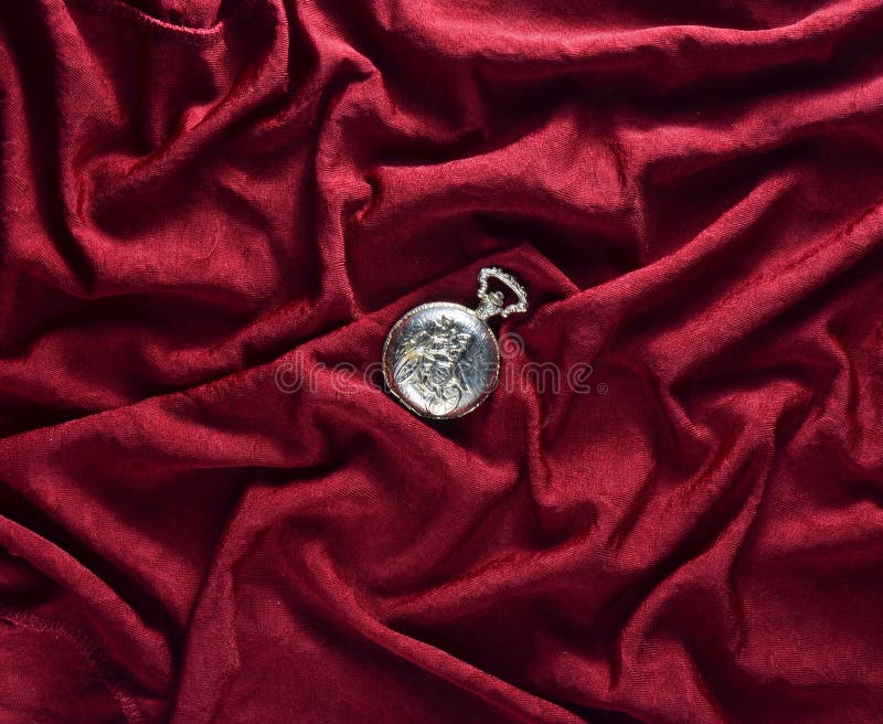 L'antiquité a fermé la montre de poche d'or sur un fond en soie rouge image stock L'antiquité a fermé la montre de poche d'or sur un fond en soie rouge image stock