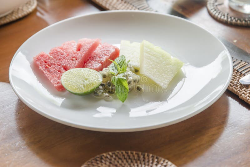 L'aperitivo fruttifica in stoviglie della porcellana del modello con il fondo di legno della tavola fotografia stock libera da diritti L'aperitivo fruttifica in stoviglie della porcellana del modello con il fondo di legno della tavola fotografia stock libera da diritti