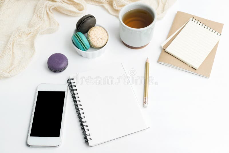 L'appartement de vue supérieure étendent la maquette vide de carnet et de téléphone portable avec des macarons et la tasse de thé photo libre de droits L'appartement de vue supérieure étendent la maquette vide de carnet et de téléphone portable avec des macarons et la tasse de thé photo libre de droits