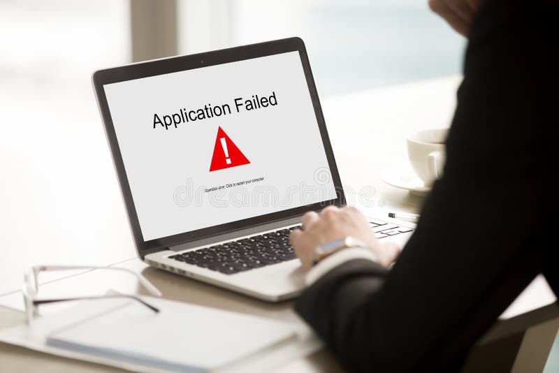 Application failed, businessman having problem with laptop, bad software failure on screen, broken computer stopped working in office, hanging pc caused system crash error message, close up rear view. Application failed, businessman having problem with laptop, bad software failure on screen, broken computer stopped working in office, hanging pc caused system crash error message, close up rear view