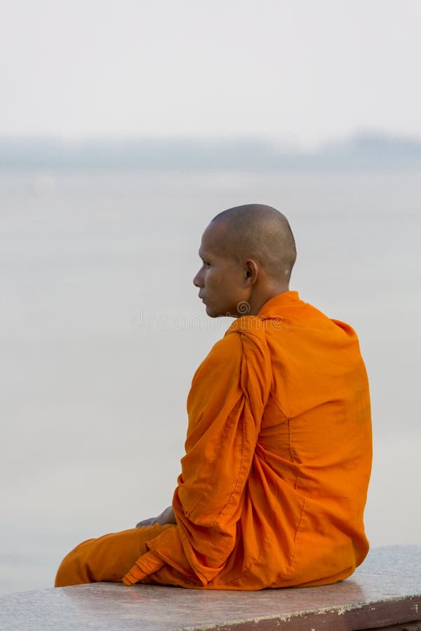 L'arancia ha vestito il monaco cambogiano che esamina il Mekong, Phnom Penh fotografie stock L'arancia ha vestito il monaco cambogiano che esamina il Mekong, Phnom Penh fotografie stock