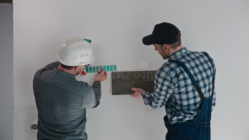 L'architetto sviluppatore e il costruttore selezionano i materiali per il completamento dell'appartamento. un costruttore maschio archivi video