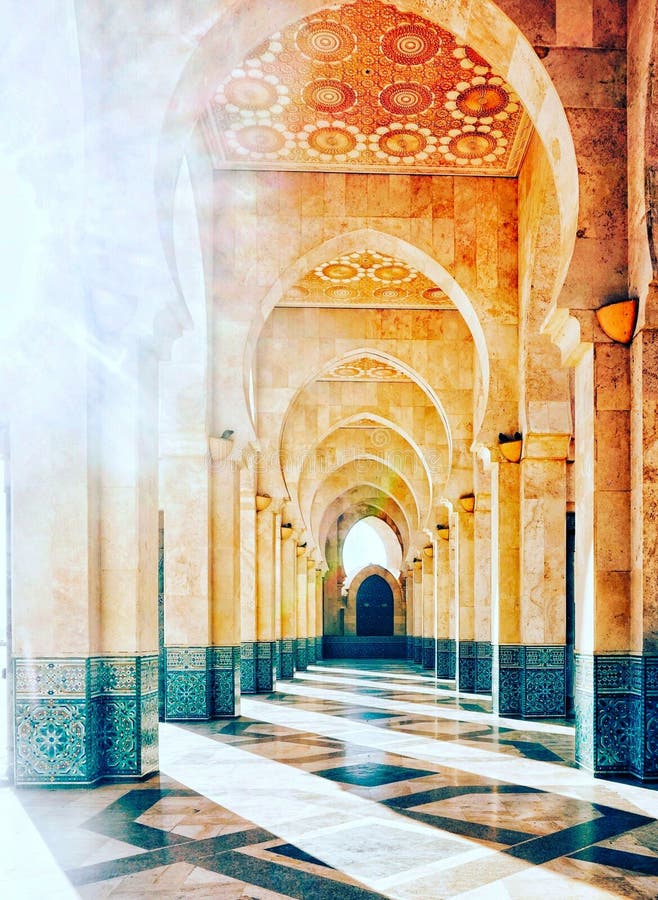 The brilliant sunshine streaming into archway Hassan mosque. Intricate exterior marble and mosaic stone archway outside of Hassan II Mosque in Casablanca, Morocco. The brilliant sunshine streaming into archway Hassan mosque. Intricate exterior marble and mosaic stone archway outside of Hassan II Mosque in Casablanca, Morocco.