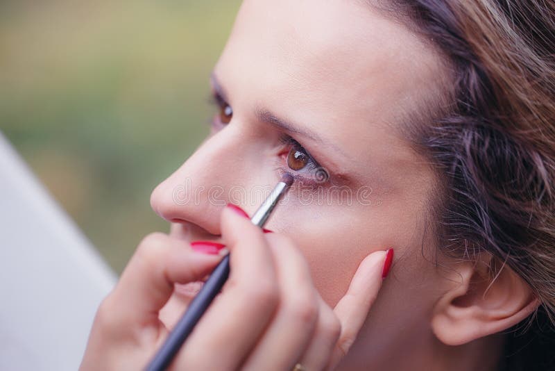 L'artista che fa il professionista compone di giovane bella donna fotografia stock libera da diritti L'artista che fa il professionista compone di giovane bella donna fotografia stock libera da diritti