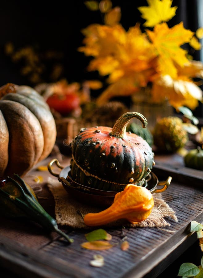 L'automne encore la vie avec des citrouilles et le bouquet des feuilles d'automne sur une table rousse brune