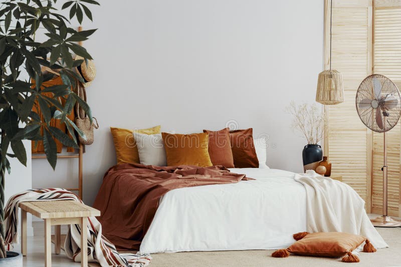 L'autunno ha colorato i cuscini su letto a due piazze nell'interno elegante della camera da letto fotografia stock libera da diritti