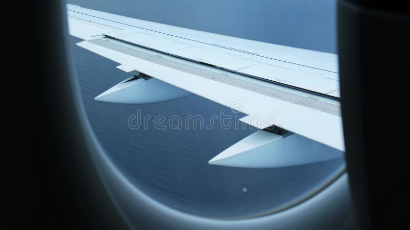L'avion descend pour atterrir. Vue depuis la fenêtre de l'avion d'une aile avec volets déplacés en action clips vidéos