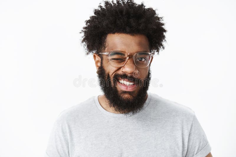 He L?cheln Portr?t des optimistischen und frohen h?bschen Afroamerikanerkerls in der guten Laune blinzelnd an der Kamera freundli lizenzfreie stockbilder He L?cheln Portr?t des optimistischen und frohen h?bschen Afroamerikanerkerls in der guten Laune blinzelnd an der Kamera freundli lizenzfreie stockbilder