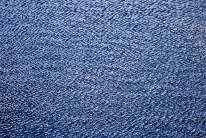 L'eau bleue de lac avec la surface d'ondulations Texture ondul?e de l'eau Petites vagues dans l'?tang Texture fra?che d'eau propr photographie stock libre de droits L'eau bleue de lac avec la surface d'ondulations Texture ondul?e de l'eau Petites vagues dans l'?tang Texture fra?che d'eau propr photographie stock libre de droits