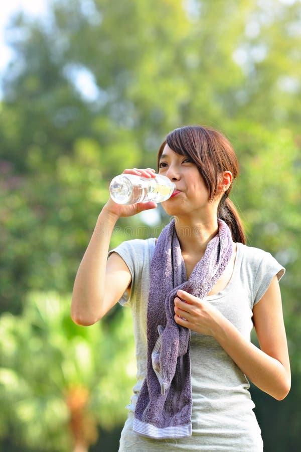 L'eau de boissons de femme après sport image libre de droits L'eau de boissons de femme après sport image libre de droits