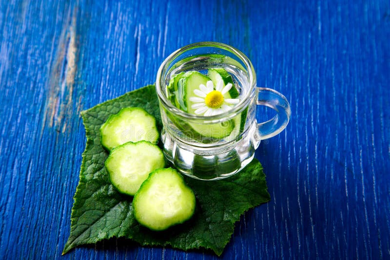 L'eau de concombre dans le pot en verre de petit maçon sur le fond bleu rustique photos libres de droits L'eau de concombre dans le pot en verre de petit maçon sur le fond bleu rustique photos libres de droits