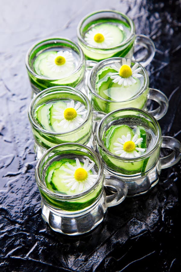 L'eau de concombre dans six pots en verre de petit maçon sur le fond noir images libres de droits L'eau de concombre dans six pots en verre de petit maçon sur le fond noir images libres de droits