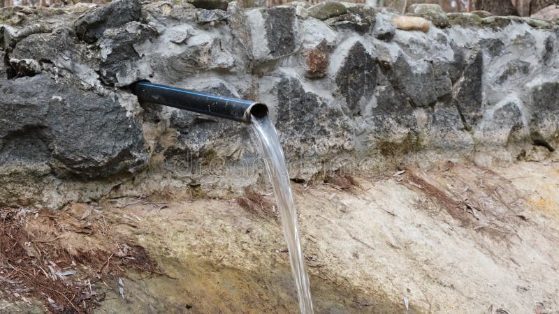 L'eau de source sort d'un tuyau métallique. ruisseau d'eau potable propre provenant de la conduite dans un petit ruisseau clips vidéos